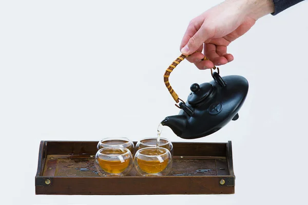 Elini şeffaf bir fincan çay tabloda çay dökülen