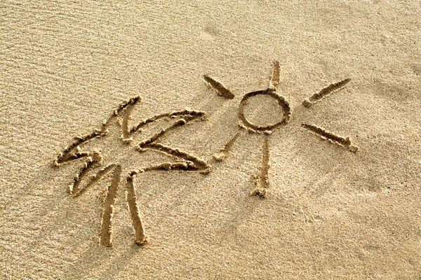 Palma y sol dibujando en la arena de la playa — Foto de Stock