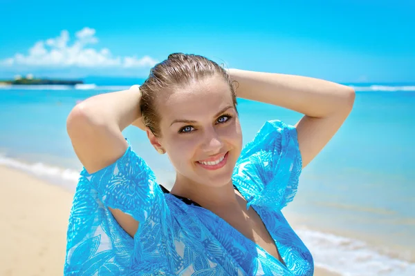 Jonge vrouw die lacht op camera voor kust — Stockfoto