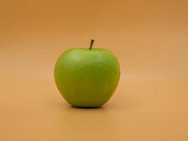 Altın bir fonda bir yeşil elma