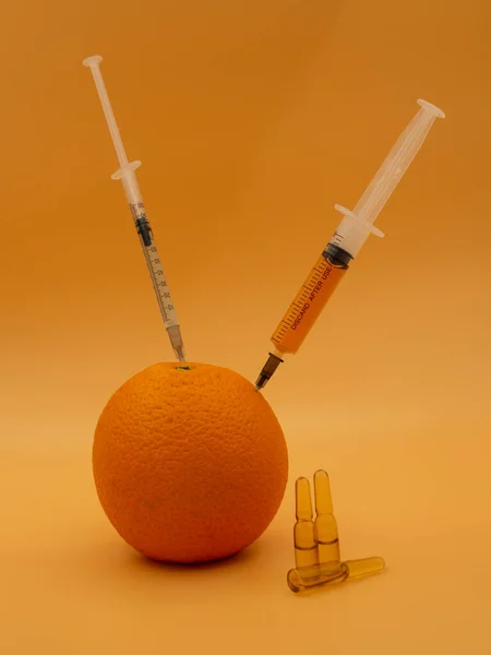 遺伝子組み換え品だ 注射器付きGmoオレンジグレープフルーツ 金運を背景に孤立 — ストック写真