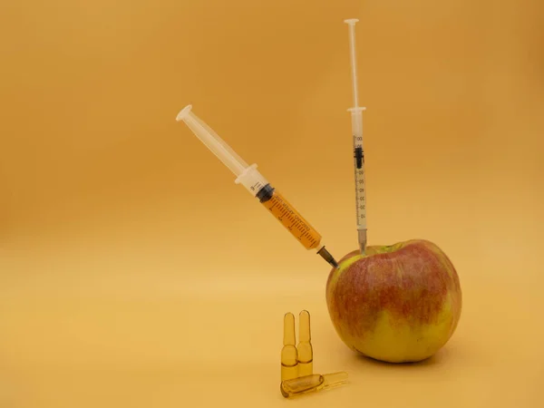 遺伝子組み換え品だ 注射器付きGmo赤大きなリンゴ 金運を背景に孤立 — ストック写真