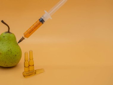 Genetik olarak değiştirilmiş bir ürün. GDO yeşil armut ve şırınga. Altın servetin arka planında izole edilmiş..