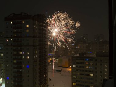 Rus banliyölerinde yeni yıl ya da Noel havai fişekleri. Şehrin uyuma alanının avlusundaki renkli bir selamlamanın birleşik fotoğrafı..