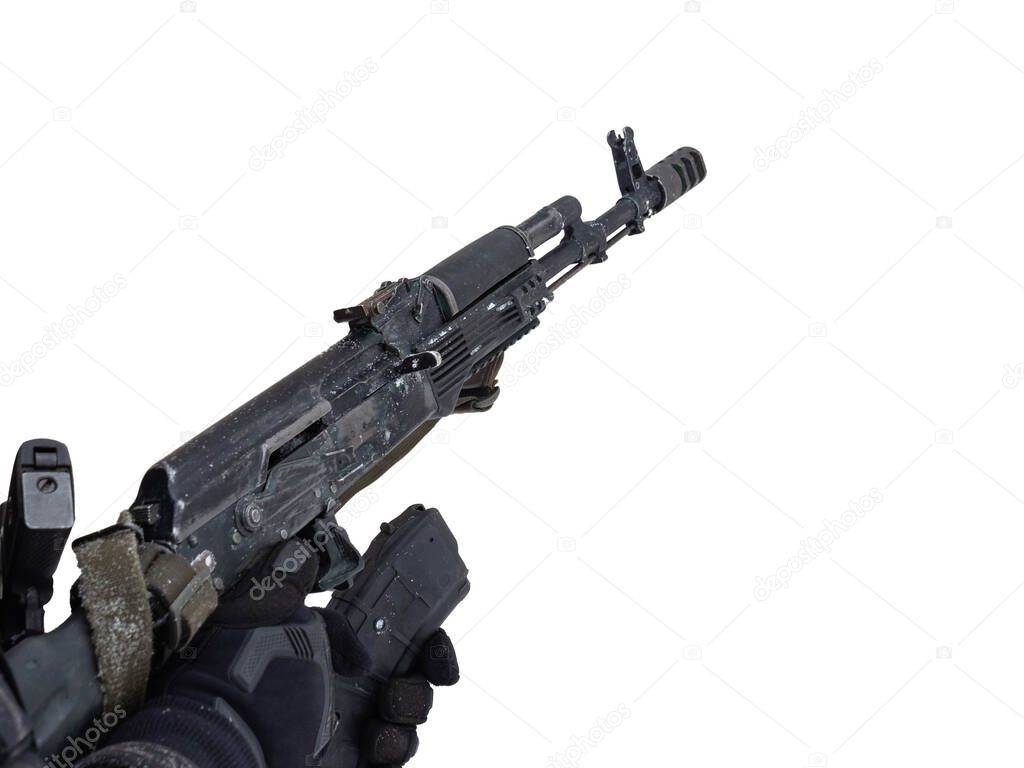 A male police officer in tactical black gloves reloads an automatic rifle in his hands. The concept of criminal offense, robbery, murder, terrorist act, sports shooting.