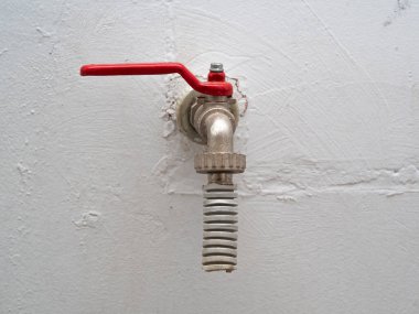 Acil durum, beyaz bir duvarın arka planında yangın musluğu. Sıcak, yoksul (yoksul) ülkelerde el yapımı ev yapımı su kaynağı kavramı.