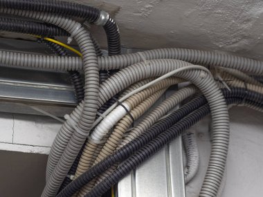 Çok renkli elektrik kabloları (kablo), endüstriyel bir binanın tavanında siyah beyaz kravatlarla sabitlenmiş optik fiber. Haberleşme yayını, internet bağlantısı.