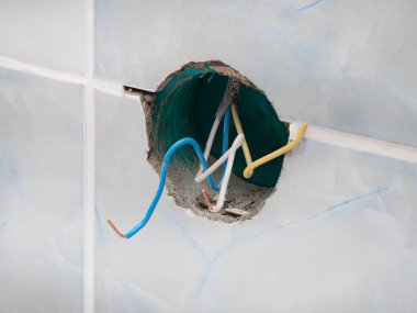 Parçalanmış, banyodaki kablolarla elektrik prizini koparmış. Kırık bir prizden kaynaklanan elektrik şoku hasarı tehlikesi kavramı. Ev elektrik şebekesinin onarımı ve restorasyonu.