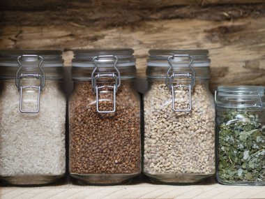 Yedek ürünler depoda, barınakta. Mısır gevreği, yulaf lapası, ahşap bir rafta cam kavanozlarda çay. Köy mutfağında yemek. Hayatta kalma, felaket, kriz durumlarında stratejik rezervlerin önlenmesi