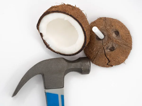 Dwie Połówki Kokosowe Pękniętą Miazgą Pęknięciami Białym Tle Obok Młotka — Zdjęcie stockowe