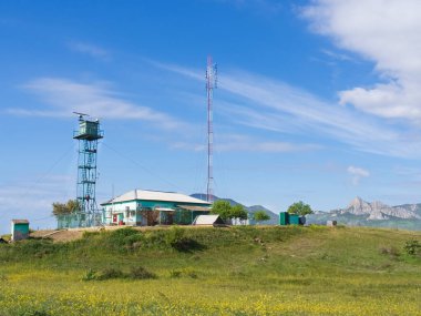 Körfezin kıyısındaki dağların arka planındaki teknik gözlem noktası. Dikenli tellerin arkasında, radar kulesi ve baz istasyonu olan yalnız bir bina. Kırım. Küçük bir sınır karakolu, bir hava istasyonu..
