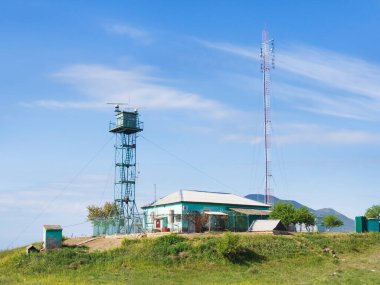 Körfezin kıyısındaki dağların arka planındaki teknik gözlem noktası. Dikenli tellerin arkasında, radar kulesi ve baz istasyonu olan yalnız bir bina. Kırım. Küçük bir sınır karakolu, bir hava istasyonu..