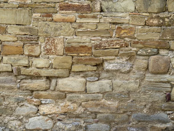 Düz olmayan taş tuğlalardan yapılmış taş döküntüsü dokusu. Kırım 'daki tarihi şatonun arka planı. Kalenin sarı tuğlaları harabe..