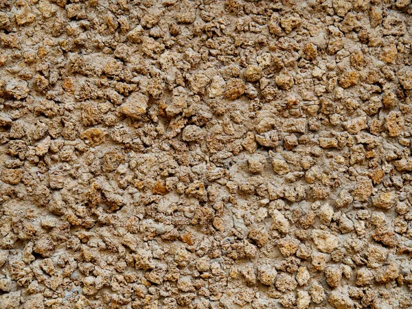 The texture of a sand wall - traditional desert architecture. Background compressed, dried yellow sand.