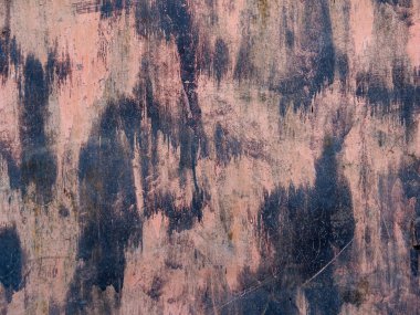 Kirli, tırmalanmış demir bir duvarın dokusu. Pembe grunge arka planda demir bir tabakanın üzerinde siyah boya lekeleri var. Sanayi benekli, yapılandırılmış arkaplan.