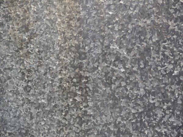 The texture is a sheet of galvanized gray spotted iron in full screen. Metal sheathing. Industrial dirty background close-up.