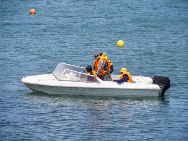 YALTA, Autonomous Republic of Crimea-06.19.2021: Motor boat with coast rescuers in orange vests patrolling the beach. Flood, rescue and search for people.