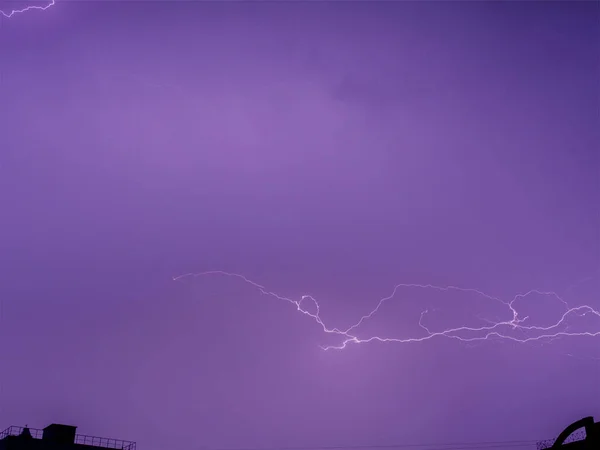几颗闪电在同一栋高楼大厦的城区背景下同时射来射去 暴风雨带来了夜间的雷雨 长期曝光的复合照片 — 图库照片