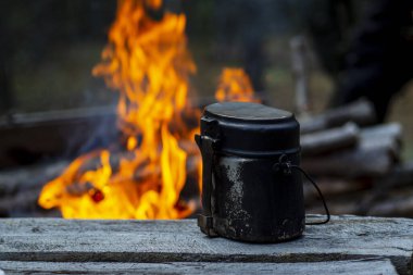 Alacakaranlıkta masada bir ordu melon şapkası. Tencerede yemek pişirmek ya da ormanın arka planında kamp ateşi yakmak..