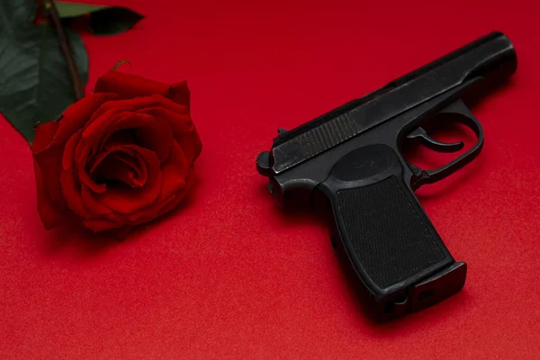 Pembe Arka Planda Kırmızı Bir Gül Siyah Bir Gangster Silahının — Stok fotoğraf