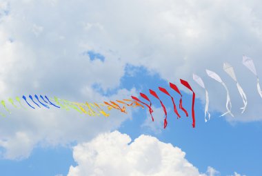 Bulutlu gökyüzü mavi karşı çok renkli bayraklar şerit biridir