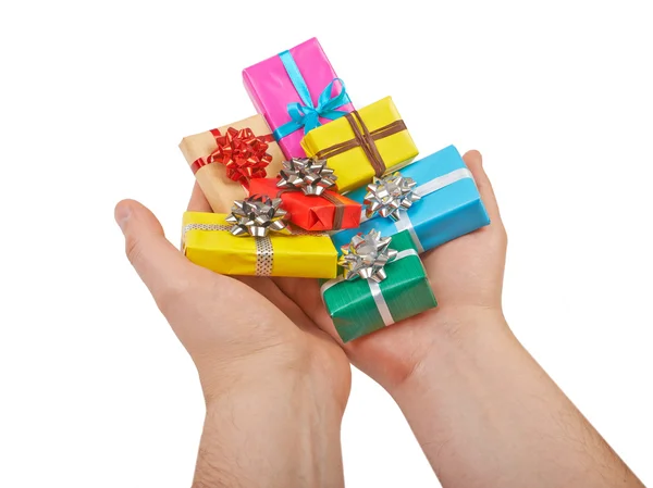 Many colored gift boxes in hands isolated on white background — Stock Photo, Image