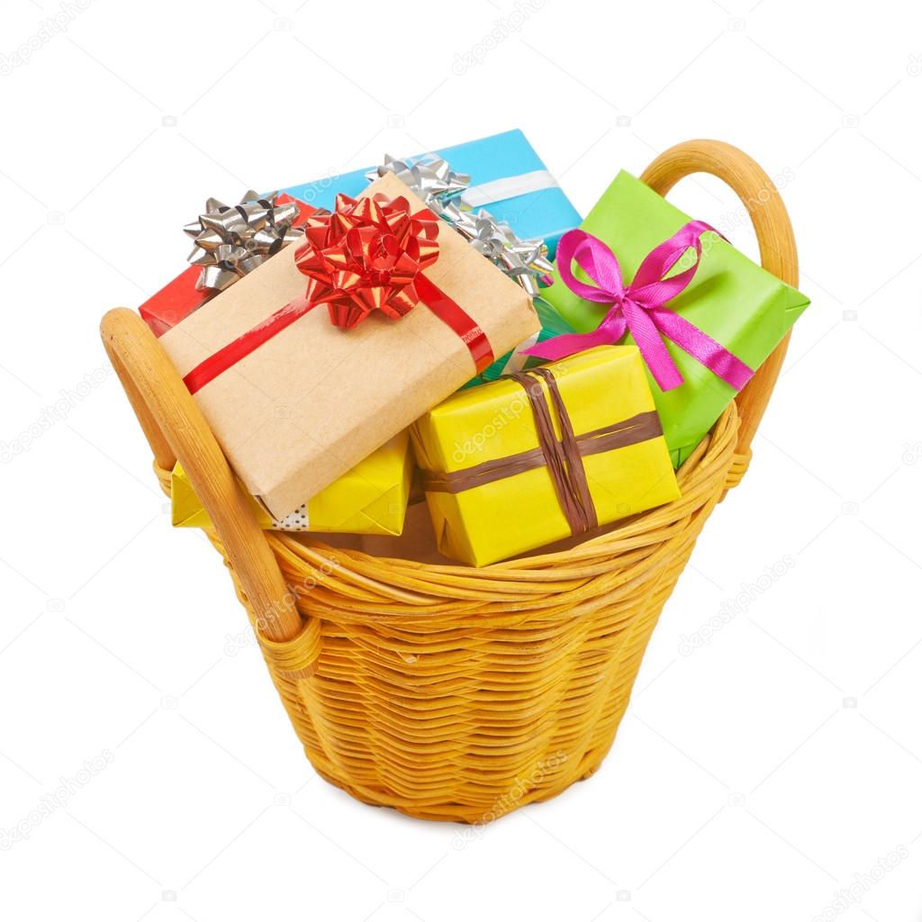 Many colored gift boxes in a basket isolated on white background