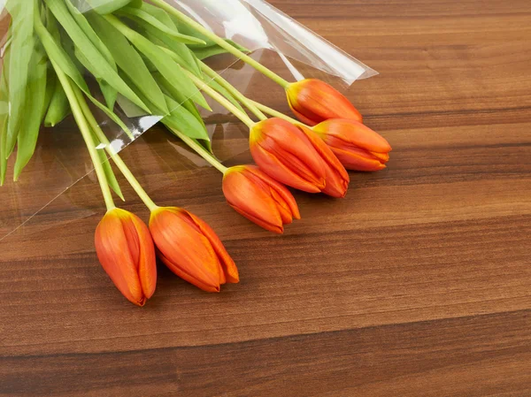 Flores vermelhas da tulipa sobre a mesa, fundo — Fotografia de Stock