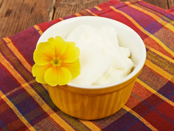 Ice cream in a bowl on a saucer and flower — Stock Photo, Image