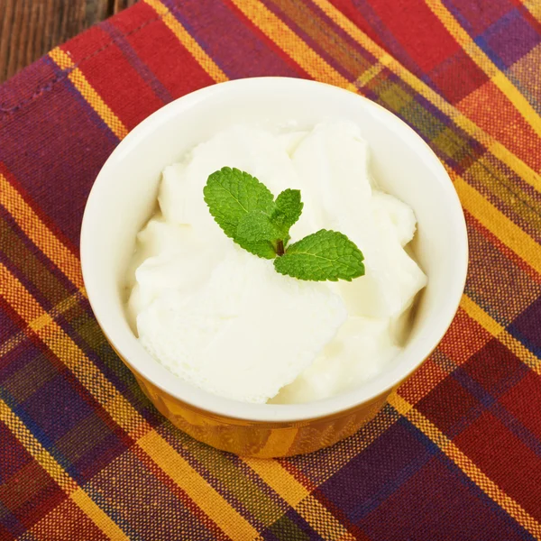 Ice cream in a bowl on a saucer and flower — Stock Photo, Image