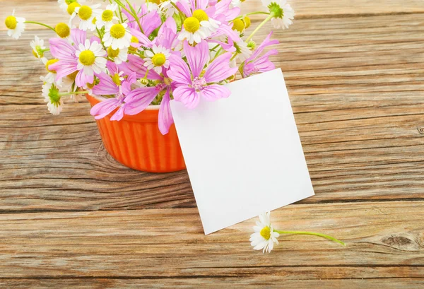 Flowers and a white blank sheet of paper — Zdjęcie stockowe