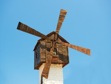 Old wooden windmill on blue sky background clipart