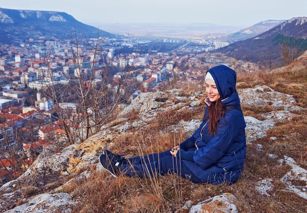 Young woman in a coat sitting — Stock Photo, Image