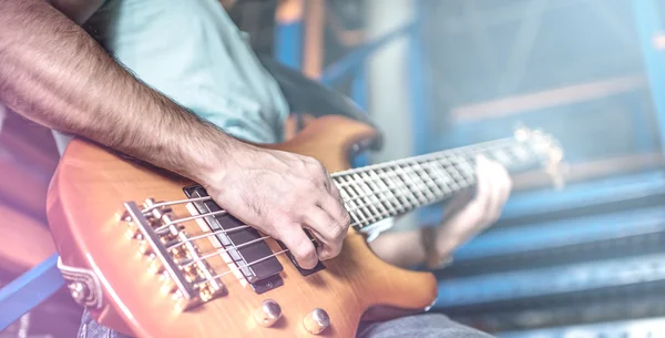 Man spelar gitarr på scen omgiven av ljus — Stockfoto