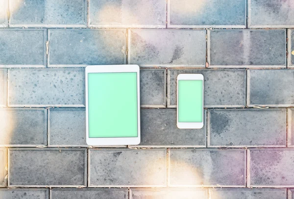 Smartphone y tableta maqueta PC contra una pared de ladrillo — Foto de Stock