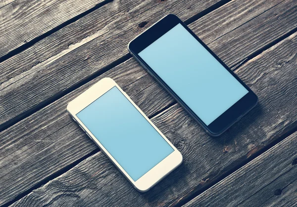 Two mockup smartphones on a wooden table — Stock Photo, Image