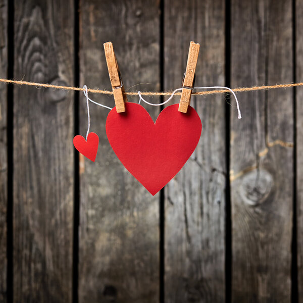 Two paper hearts hang on clothesline