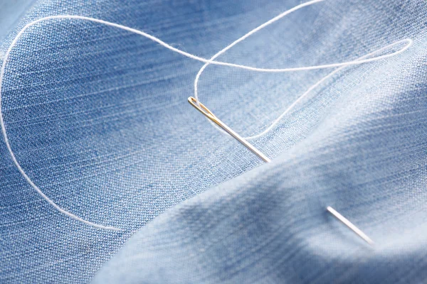 Needle with thread on jeans material — Stock Photo, Image