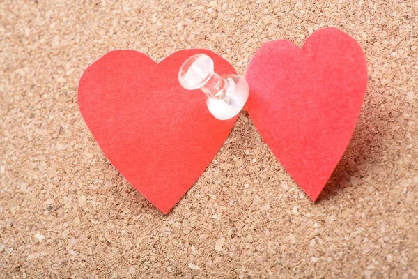 Paper hearts with pin on cork-board — Stock Photo, Image