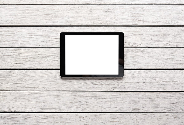 Digital tablet computer with isolated screen on white wooden desk.