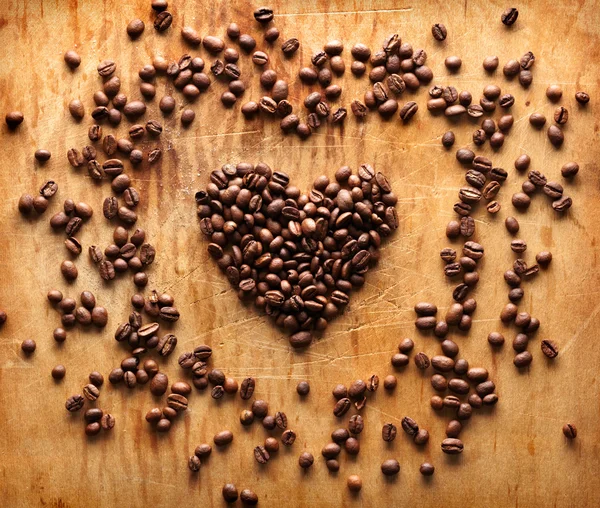 Форма сердца из коричневых кофейных зерен — стоковое фото