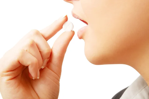 Woman in suit taking white pil — Stock Photo, Image