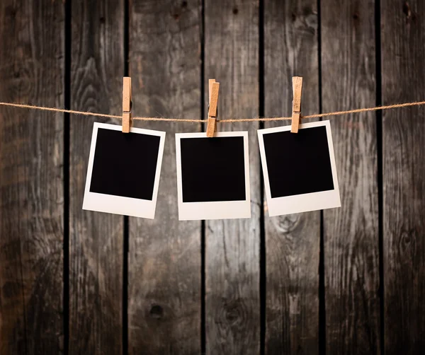 Three blank instant photos on the clothesline — Stock Photo, Image