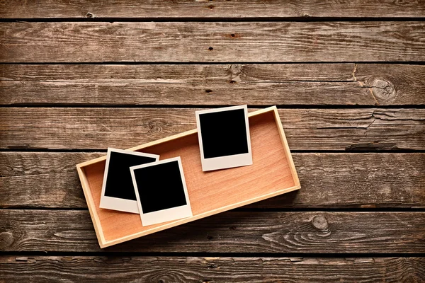 Instant photo frames on wooden box — Stock Photo, Image