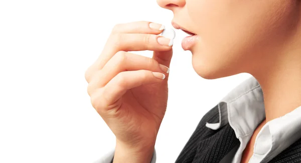 Woman in suit taking white pil — Stock Photo, Image