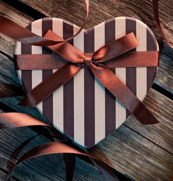 Confezione regalo con nastro curvo su legno vecchio — Foto Stock