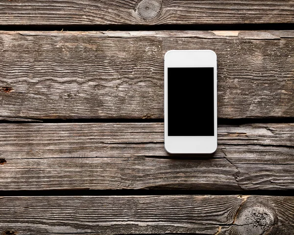 Téléphone intelligent sur vieux bureau en bois — Photo