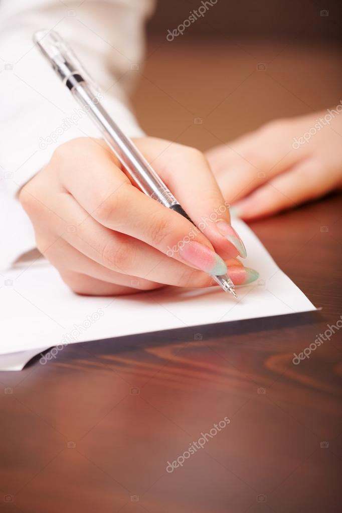 Woman hand writing on paper