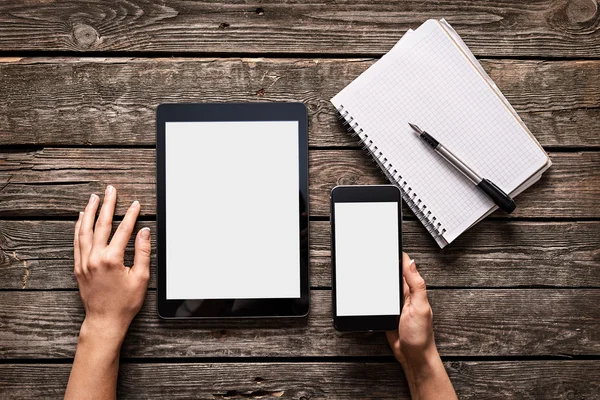 Woman holds smartphone with tablet