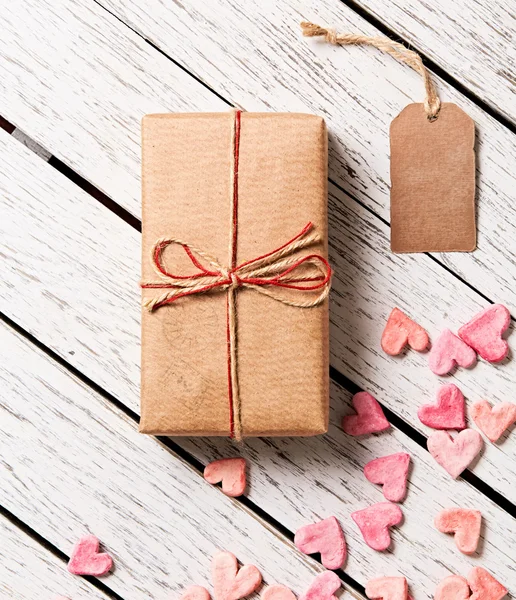 Caja de regalo con etiqueta de regalo en blanco y montón de corazones — Foto de Stock